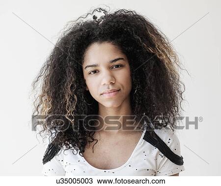 Stock Image - Portrait of teenage girl (16-17) on white background. Fotosearch