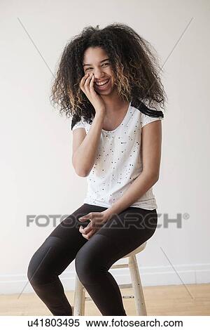 Portrait of teenage girl (16-17) sitting on stool View Large Photo Image Stock Photography - Portrait of teenage girl (16-17) sitting on stool. Fotosearch