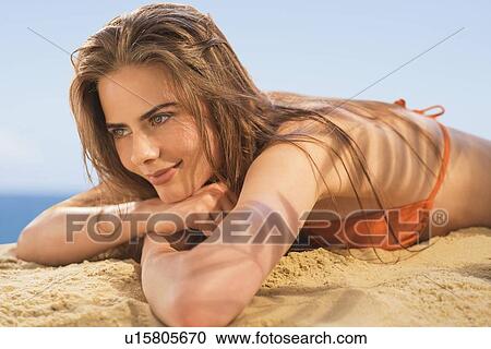 Portrait of young woman lying on beach View Large Photo Image Stock Image - Portrait of young woman lying on beach. Fotosearch