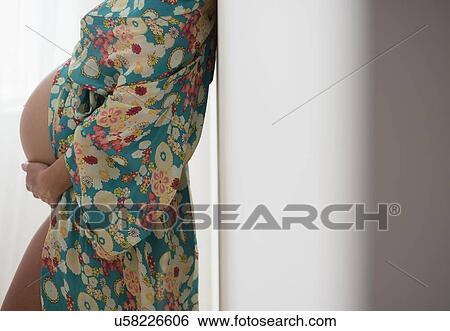 Stock Photograph - Pregnant woman in colorful dressing gown. Fotosearch