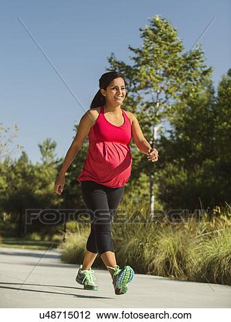 Pregnant woman walking outdoors View Large Photo Image Stock Image - Pregnant woman walking outdoors. Fotosearch