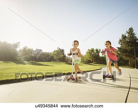 Picture - Sisters (6-7, 8-9) playing in park. Fotosearch