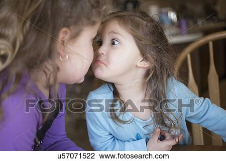 Stock Image - Sisters making faces at each other. Fotosearch