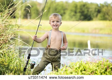 Picture - Smiling boy (4-5) holding fishing rod. Fotosearch