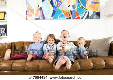 Smiling children (2-3, 4-5, 6-7) sitting on sofa View Large Photo Image Picture - Smiling children (2-3, 4-5, 6-7) sitting on sofa . Fotosearch
