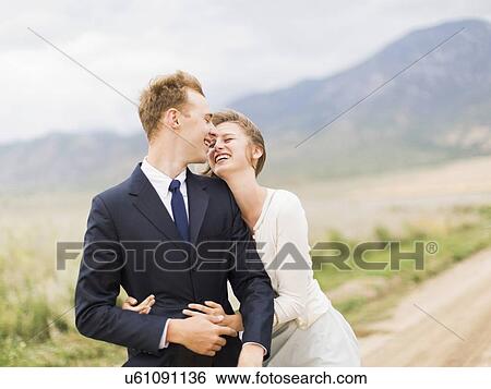 Stock Photograph - Smiling newlywed couple embracing . Fotosearch