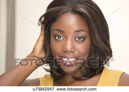 Stock Photo - Smiling woman with hand in hair. Fotosearch