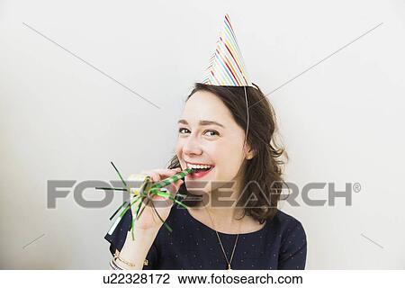 Smiling young woman with party horn blower View Large Photo Image Stock Image - Smiling young woman with party horn blower. Fotosearch