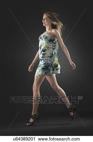 Studio shot of young woman walking View Large Photo Image Stock Image - Studio shot of young woman walking. Fotosearch