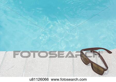 Stock Photograph - Sunglasses on pool side. Fotosearch