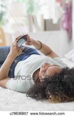 Teenage girl (16-17) texting in bedroom View Large Photo Image Stock Photo - Teenage girl (16-17) texting in bedroom. Fotosearch