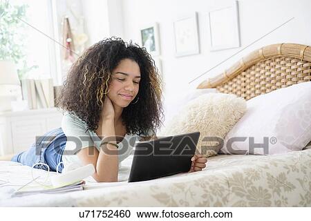 Stock Image - Teenage girl (16-17) using tablet pc. Fotosearch
