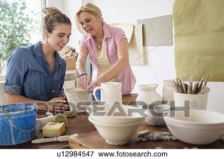 Two women making pottery in studio View Large Photo Image Stock Photo - Two women making pottery in studio. Fotosearch