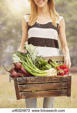 Woman carrying fresh vegetables in box View Large Photo Image Stock Image - Woman carrying fresh vegetables in box. Fotosearch
