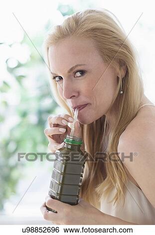 Woman drinking from bottle View Large Photo Image Stock Photograph - Woman drinking from bottle. Fotosearch