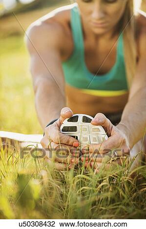 Stock Image - Woman exercising in field. Fotosearch