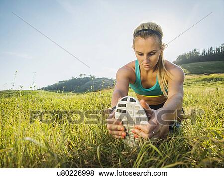 Stock Photo - Woman exercising in field. Fotosearch