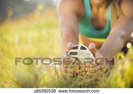 Stock Photo - Woman exercising in field. Fotosearch