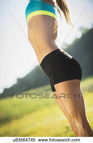 Stock Photography - Woman exercising in field. Fotosearch
