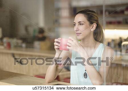 Woman holding coffee cup in cafe View Large Photo Image Picture - Woman holding coffee cup in cafe. Fotosearch
