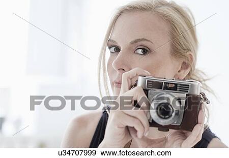 Stock Photo - Woman holding digital camera. Fotosearch