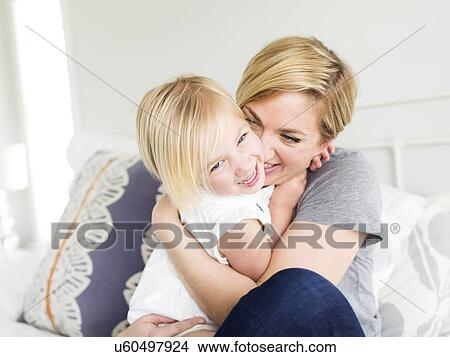 Woman hugging daughter (2-3) in bedroom View Large Photo Image Picture - Woman hugging daughter (2-3) in bedroom. Fotosearch