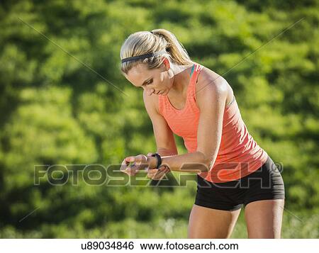 Stock Photograph - Woman looking at watch. Fotosearch