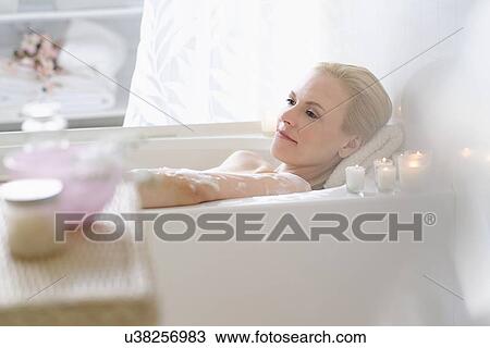 Stock Image - Woman relaxing in bath. Fotosearch