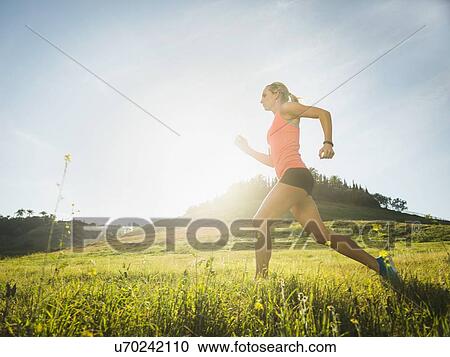 Woman running in field View Large Photo Image Stock Image - Woman running in field. Fotosearch