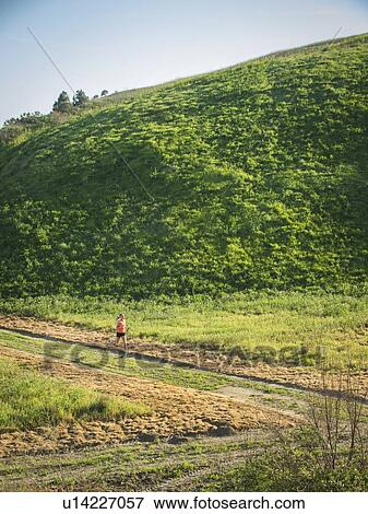 Woman running in field View Large Photo Image Stock Photo - Woman running in field. Fotosearch