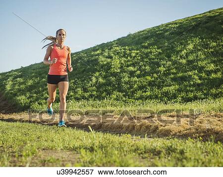 Woman running in field View Large Photo Image Stock Photo - Woman running in field. Fotosearch