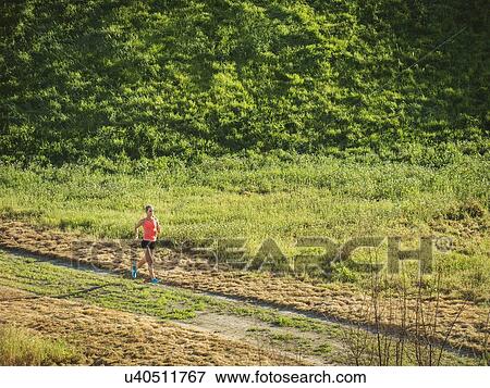 Woman running in field View Large Photo Image Stock Photo - Woman running in field. Fotosearch
