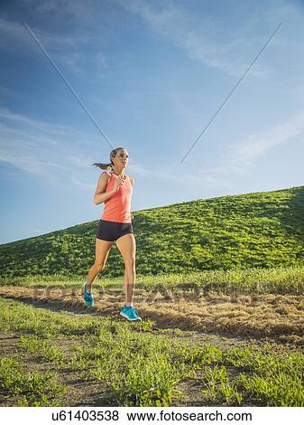 Woman running in field View Large Photo Image Stock Photo - Woman running in field. Fotosearch