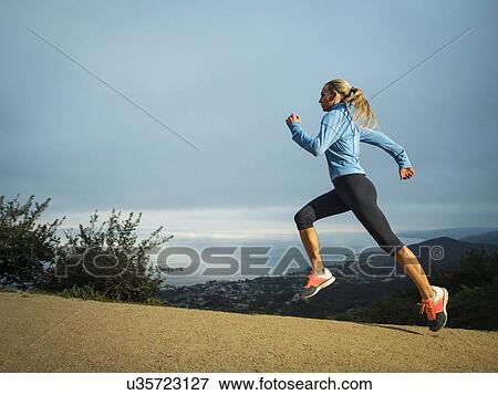Woman running in mountains View Large Photo Image Stock Photo - Woman running in mountains. Fotosearch