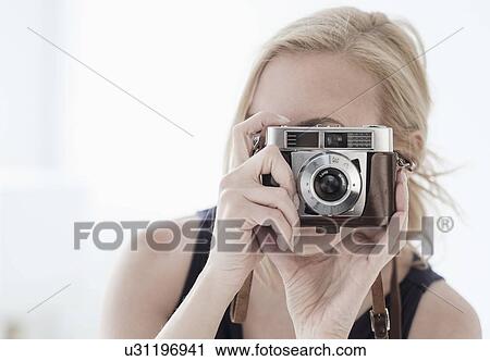 Stock Image - Woman taking photo with digital camera. Fotosearch