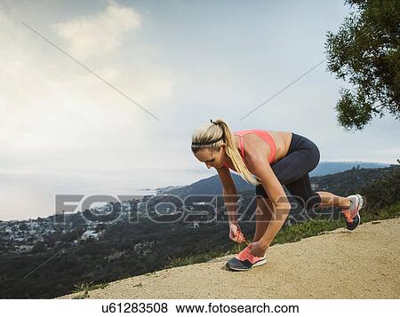 Stock Photo - Woman tying shoe. Fotosearch