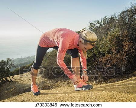 Woman tying shoe View Large Photo Image Stock Photograph - Woman tying shoe. Fotosearch