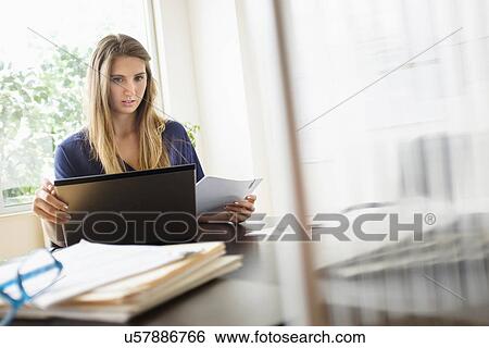 Stock Photograph - Woman working in office. Fotosearch