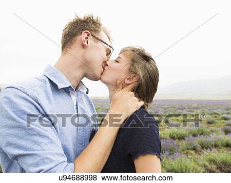Stock Photo - Young couple kissing with field on background. Fotosearch