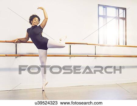 Stock Image - Young woman dancing in dance studio. Fotosearch