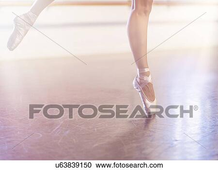 Stock Image - Young woman dancing in dance studio. Fotosearch