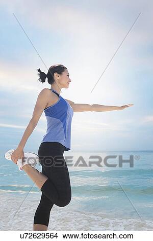Picture - Young woman exercising by sea. Fotosearch