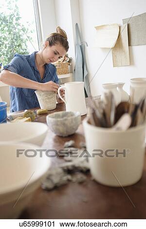 Young woman making pottery in studio View Large Photo Image Stock Image - Young woman making pottery in studio. Fotosearch