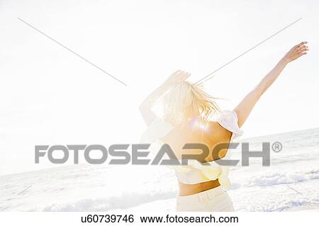Stock Photograph - Young woman on beach. Fotosearch