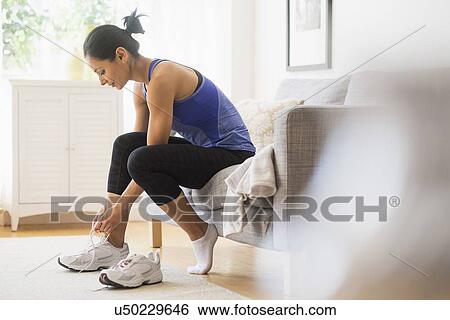 Young woman putting on shoes View Large Photo Image Stock Photograph - Young woman putting on shoes. Fotosearch