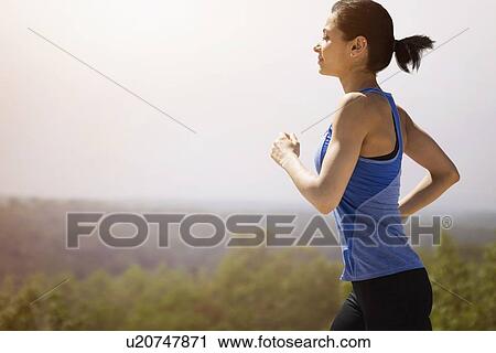 Young woman running outdoors View Large Photo Image Stock Image - Young woman running outdoors. Fotosearch