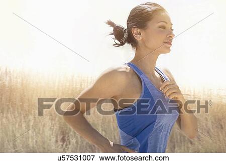 Stock Photo - Young woman running outdoors. Fotosearch