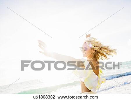 Stock Image - Young woman smiling on beach. Fotosearch