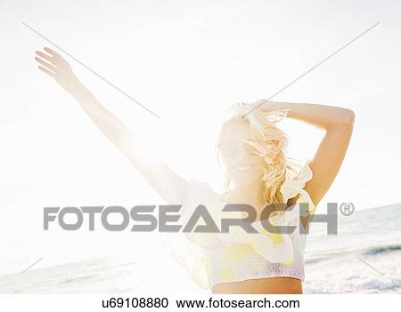 Young woman smiling on beach View Large Photo Image Stock Image - Young woman smiling on beach. Fotosearch