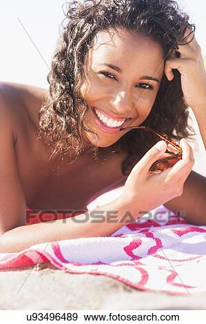 Stock Photo - Young woman smiling on beach. Fotosearch